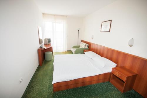 博扎瓦拉凡达酒店的一间卧室配有一张床、一张桌子和一把椅子