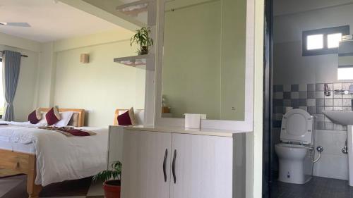 博卡拉Hotel Pristine Himalaya的一间卧室设有一张床、一个卫生间和一个水槽