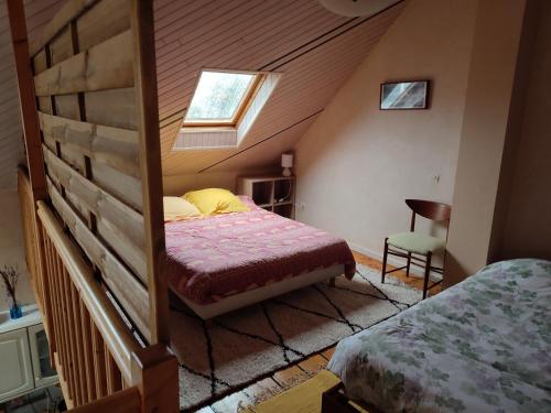 勒帕莱Pascanono - Location de maison de vacances avec jardin pour séjour à Le Palais, Belle-Ile-en-mer的阁楼卧室设有床和窗户。