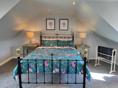 邓弗姆林NEW Fabulous 2BD Maisonette Dunfermline, Fife的一间卧室配有一张床、两张桌子和两盏灯。