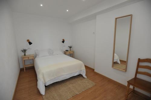 拉戈斯Lagos Central Apartments Ap 10的白色卧室配有床和镜子