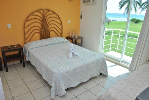 El Morro博卡拉德奥维哈斯酒店的一间卧室设有两张床和大窗户
