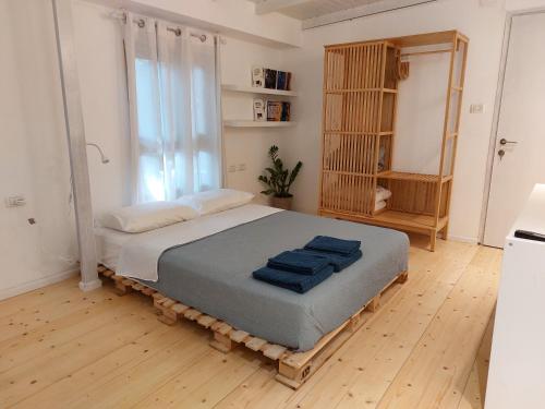 Yoqne‘amגן עדן ביקנעם המושבה的一间卧室配有一张大床,上面有蓝色的毛巾