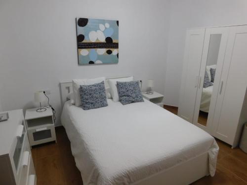 蓬塔穆赫雷斯Estudio SERMAR的一间卧室配有白色床和蓝色枕头
