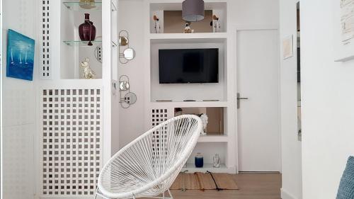 尼斯Superbe appartement style architecte/unique**的客厅设有一张白色椅子,配有电视