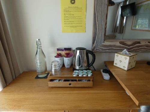 金斯布里奇The Sloop Inn的一张木桌、咖啡壶和瓶子