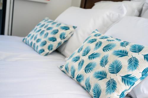 里夫杜海滩Le Clos des Fantaisies的一张带蓝色和白色枕头的床
