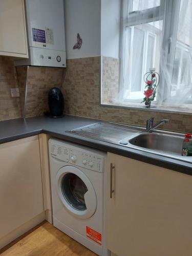 克劳利Lux Apartment in Gatwick的厨房配有洗衣机和水槽