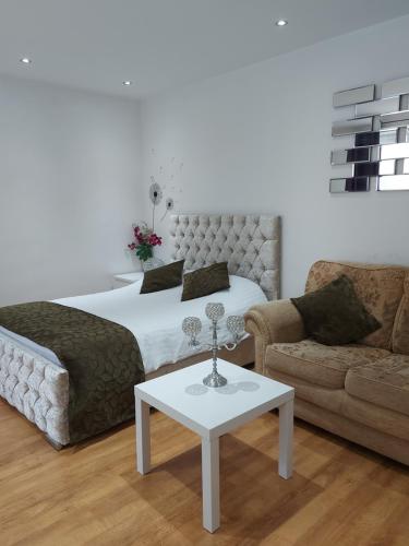 克劳利Lux Apartment in Gatwick的一间卧室配有一张床、一张沙发和一张桌子
