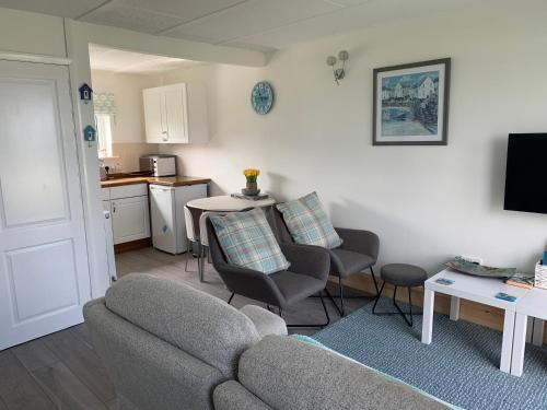 布德Chalet 26 Widemouth Bay的带沙发和椅子的客厅以及厨房。