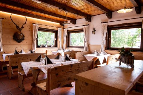 苏特廖Baita da Rico Zoncolan的一间设有木桌的餐厅,位于带窗户的房间内