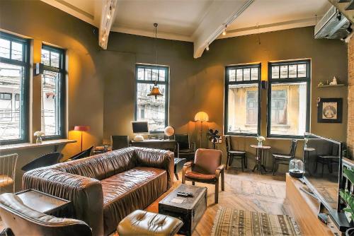 曼谷Ba Hao Residence的客厅配有真皮沙发和椅子