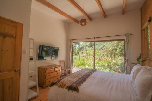 拉塞雷纳Cabañas en la naturaleza a pasos de la Playa的一间卧室设有一张床和一个滑动玻璃门