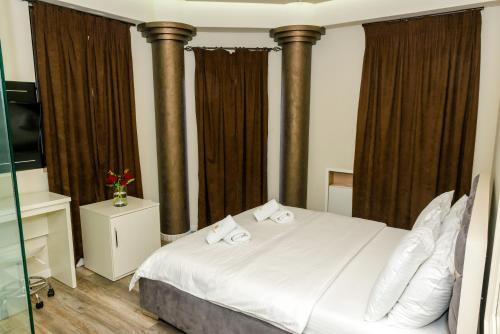 戈里察Hotel Pazari & Apartments的一间卧室配有一张床,上面有两条毛巾