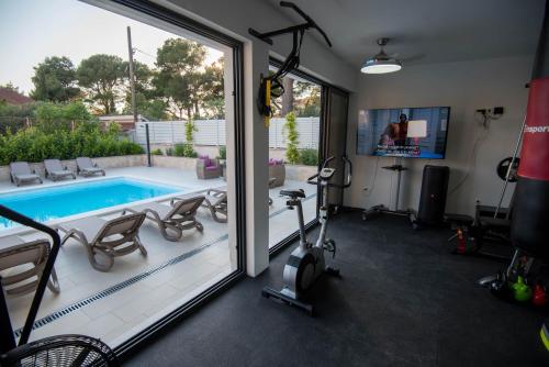 布罗达里卡Apartmani Villa Lavanda I的一个带游泳池和健身房的房间