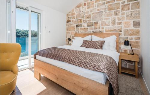 米欧纳Cozy Home In Milna With House Sea View的一间卧室设有一张床和砖墙