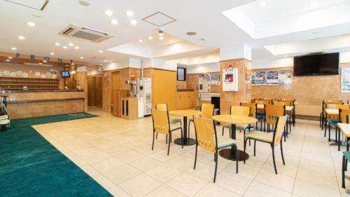 札幌Toyoko Inn Hokkaido Sapporo-eki Nishi-guchi Hokudai Mae的餐厅内带桌椅的用餐区