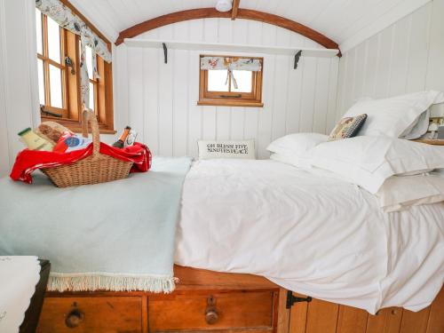 刘易斯Shepherds Hut的一间卧室配有一张大床,上面有篮子