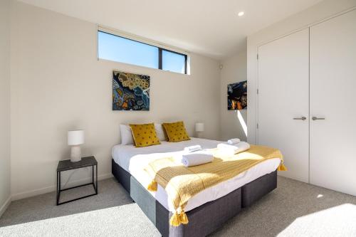 欧尼坦基Wavesong Mahe的一间卧室配有一张带黄色枕头的床和一扇窗户