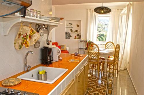 皮佐Apartment Casa Beatrice的厨房配有水槽和桌椅