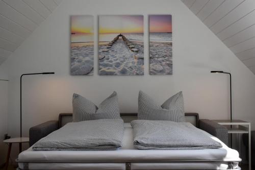 诺德奈Wohnung Wattwurm的卧室配有一张床,墙上挂有两幅画