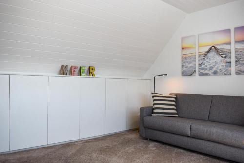 诺德奈Wohnung Wattwurm的带沙发和白色橱柜的客厅