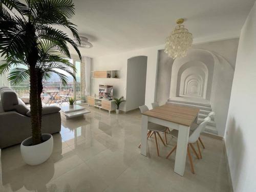 马拉加Holidays2Malaga Princesa 3 dormitorios, vistas al mar y montaña, terraza y a 200m a la playa的客厅配有桌子和棕榈树