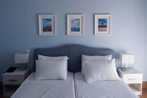 佩弗奇Mirtia Hotel的蓝色卧室配有带白色枕头的床