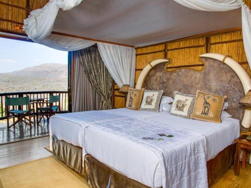 MkuzeMkuze Falls Private Game Reserve的一间带大床的卧室和一个阳台