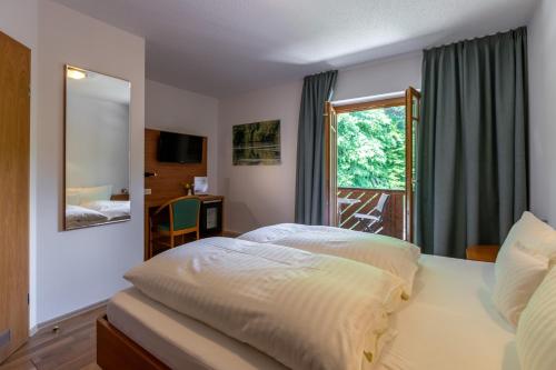 帕绍祖尔特里福特斯皮尔酒店的一间卧室设有一张大床和一个窗户。