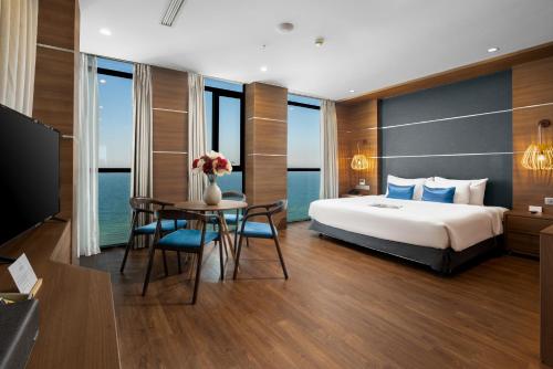 岘港海安海滩Spa酒店的酒店客房带一张床、一张桌子和椅子