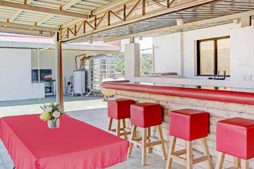 ZambalesOYO 869 Jnv Dream Hotel的一间设有红色桌子和红色凳子的餐厅