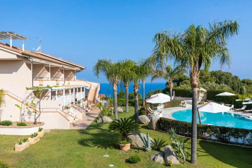 梵蒂冈角拉尔可巴利诺度假酒店的一座带游泳池和棕榈树的房子
