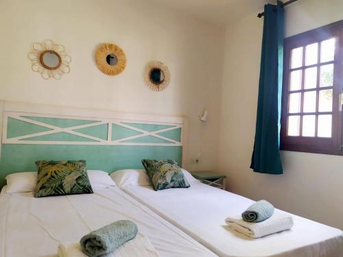 苏昂博Cheap & Chic Apartamentos en Son Bou de 2 dormitorios的一间卧室配有两张床、毛巾和窗户