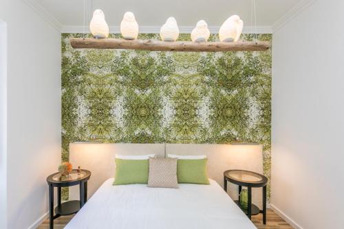 里斯本São José by SpotOn Apartments的一间卧室配有一张带绿色墙壁的床