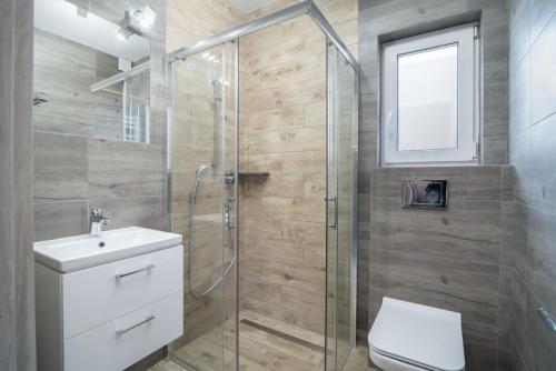 加茨比亚格拉Domki GENAKER的带淋浴、卫生间和盥洗盆的浴室