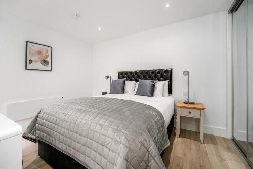 剑桥Citystay - Finch House的白色卧室配有一张大床和一张桌子