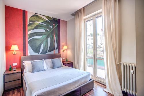 米兰Milhouse Suites Duomo的一间卧室设有一张床和一个大窗户