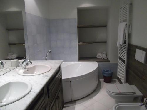 奥尔塔圣朱利奥Casa Vacanza Piazza的一间带两个盥洗盆、浴缸和卫生间的浴室