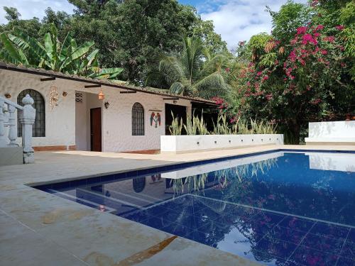 梅尔加Villa Clara Casa Campestre, Piscina, Naturaleza, Paseo de Río的房屋前的游泳池