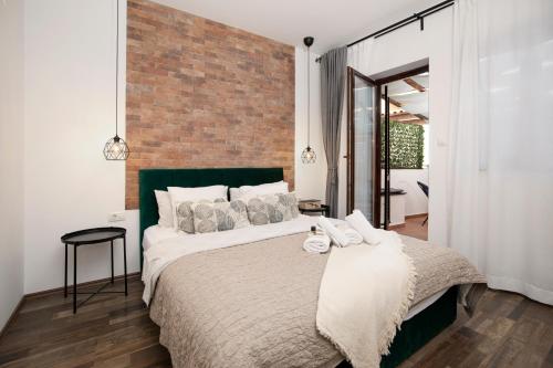 普拉Apartments Ingrid的一间卧室设有一张带砖墙的大床