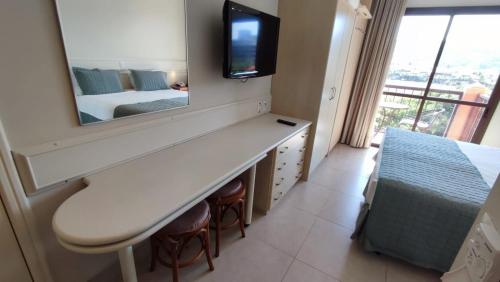 弗洛里亚诺波利斯Jurerê Beach Village的一间带镜子、一张床和电视的卧室