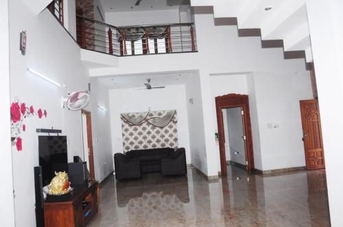 蒂鲁奇奇拉帕利Shri Sai Baba Homestay - EB Colony - Trichy的带沙发和楼梯的客厅