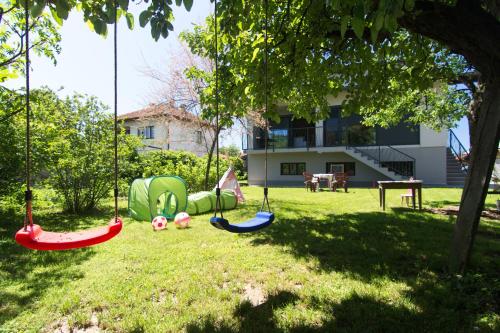维索科Modern House in Visoko的院子里草地上带秋千的游乐场