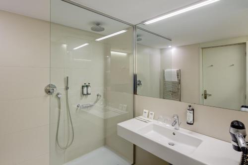 巴塞罗那Sercotel Hotel Rosellon的带淋浴和盥洗盆的白色浴室
