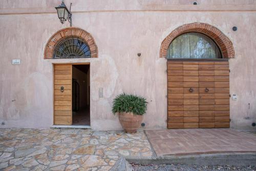 里奥托尔托Appartamento Pianosa的一座带两扇木门和盆栽的建筑