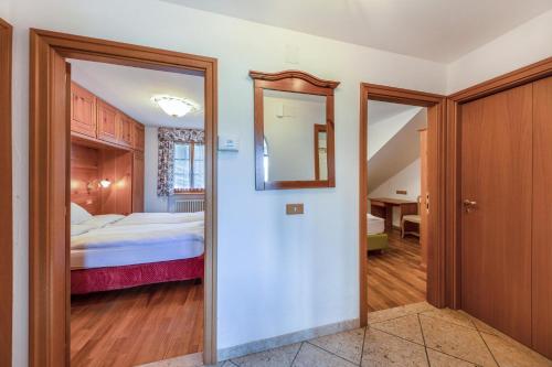 维哥迪法萨Ciasa Sommavilla Calendula的走廊通往带1张床和镜子的卧室