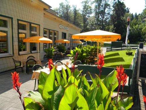 埃伦德瓦尔德木和勒酒店的户外庭院配有桌子、遮阳伞和鲜花。