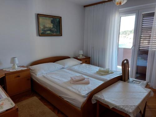 木洛希尼Room Slavica的一间卧室配有一张床,上面有两条毛巾