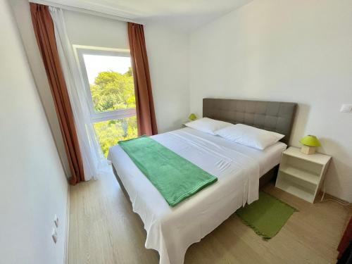 ProžuraVilla Evita Apartments的一间卧室设有一张大床和窗户
